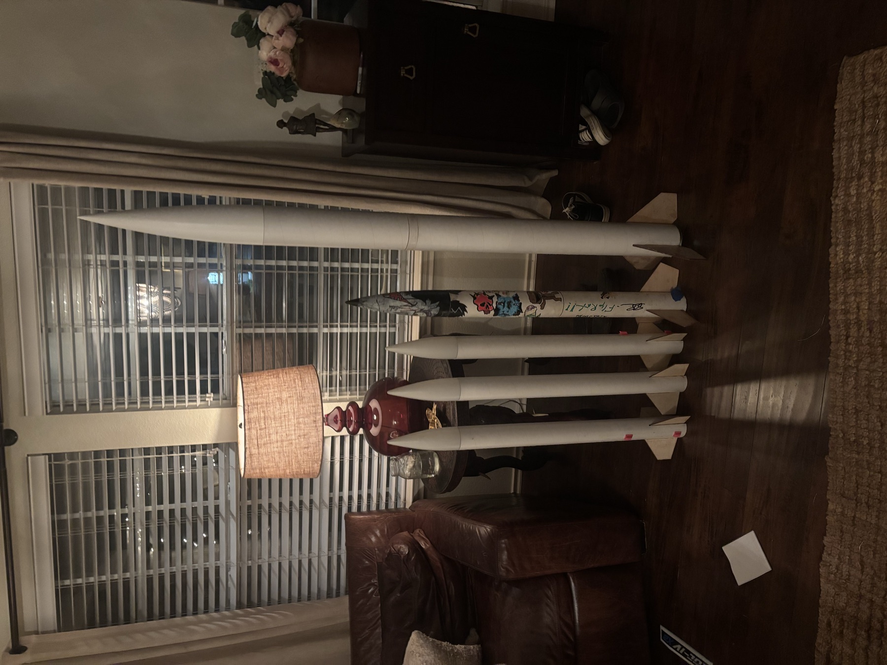Five finished rockets standing in a row in a living room