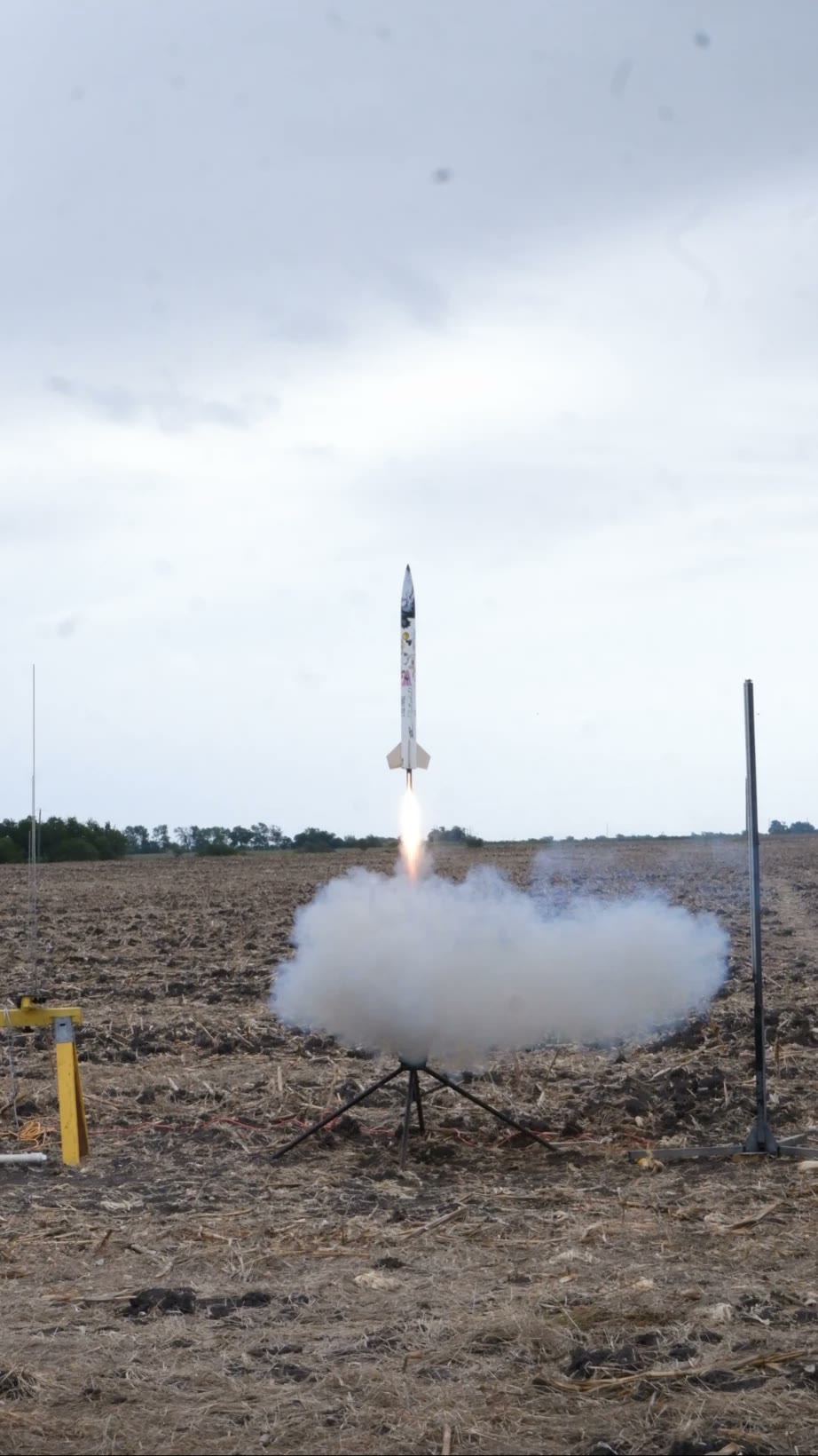 A rocket lifting off the pad on a bright flame